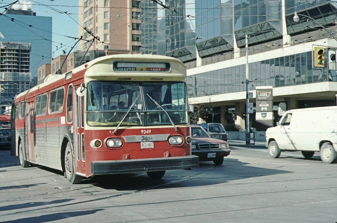 A PHOTO - TORONTO - BAY STREET WITH ATRIUM IN BACKGROUND - NOTE SIGN FOR LICHEE GARDEN RELOCATED FROM ELIZABETH - TTC TROLLEY BUS WHICH COULD USE A WASH - 1988