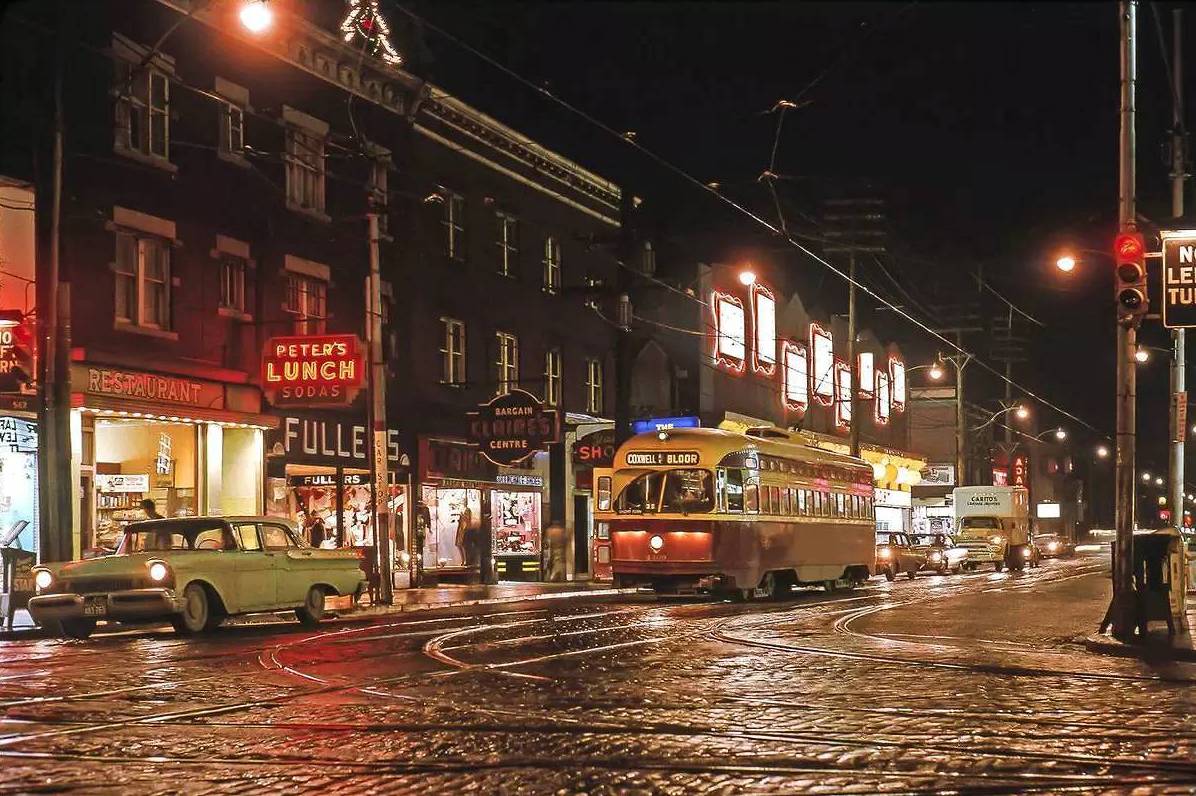 AA PHOTO - TORONTO - BLOOR JUST W OF BATHURST LOOKING S W - NIGHT - PCC STREETCAR STOPPED - HONEST ED'S BEFORE HAVING A VERY BIG SIGN - PETER'S LUNCH - EDSEL STOPPED - MID-1960s